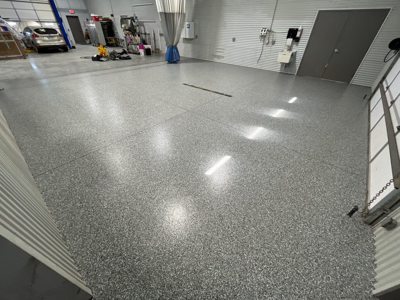 Wide view of auto body shop floor coating with clean, even texture.