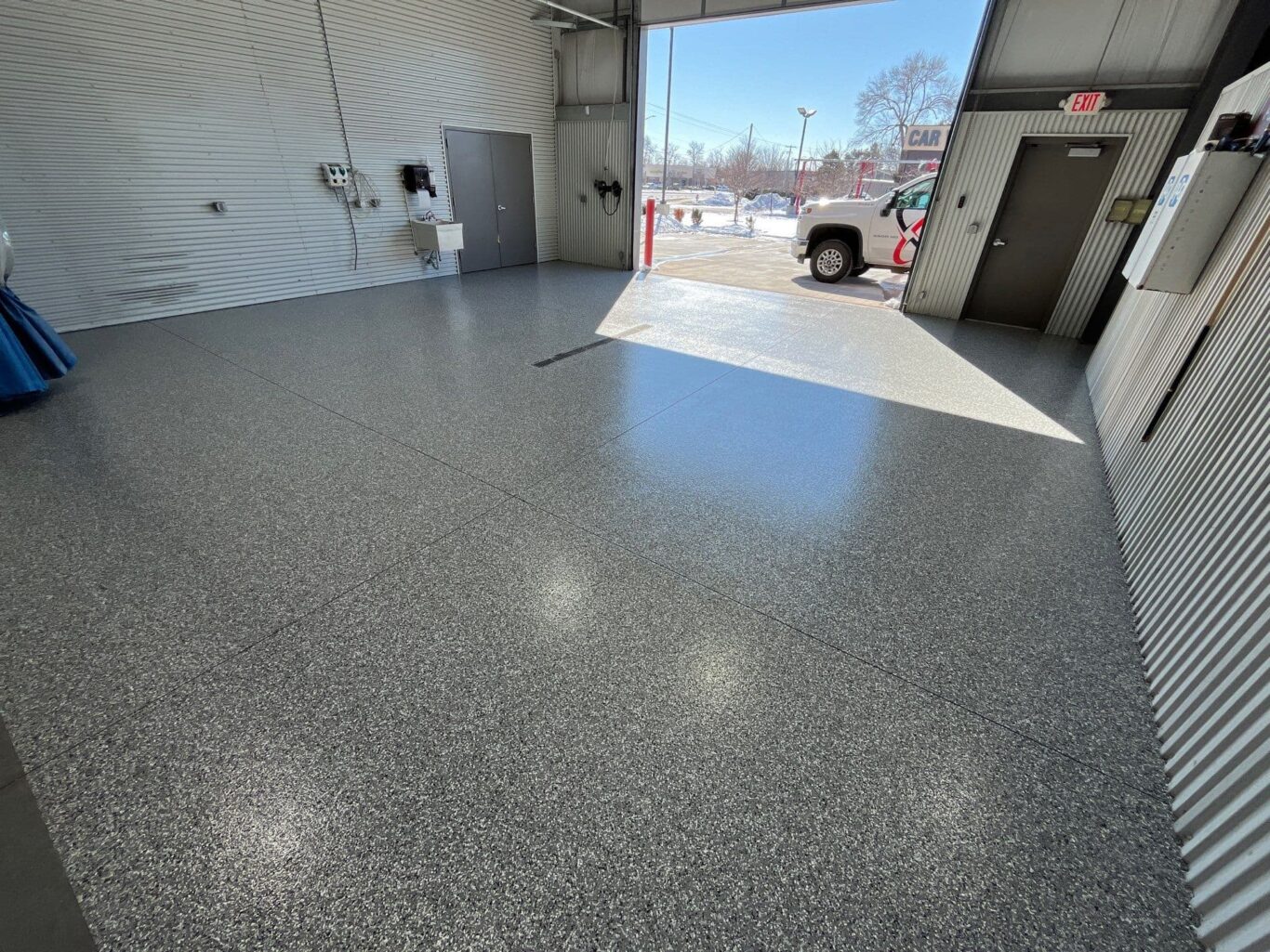 Sunlight reflecting on new Penntek shop floor near the overhead door entrance.