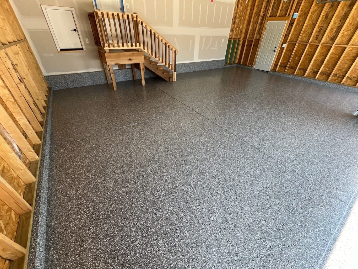 Garage floor coating with Smoke flake and integrated cove base along the walls.